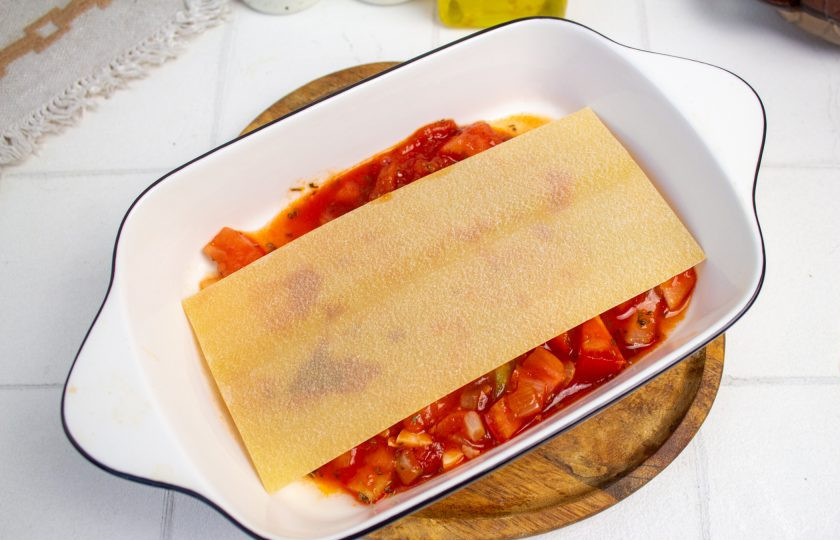1. Этап. Лазанья с помидорами и сыром: В форму для запекания налейте немного соуса и выложите листы лазаньи.