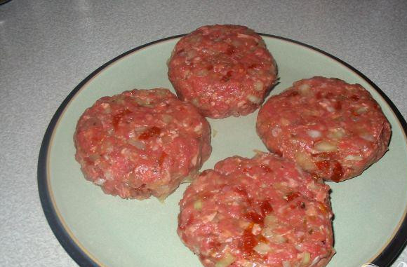 1. Этап. Домашние бургеры: 1. Почистить и мелко нарезать лук. Нарезать вяленые помидоры. Булочки разрезать пополам и подрумянить в тостере или в духовке сторону разреза. Смешать фарш, лук, яйцо, помидоры, тмин, кайенский перец в миски и хорошо перемешать руками. Разделить смесь на 4 части и сформировать круглые котлеты. Хорошо их при этом размять, чтобы они не развалились во время приготовления. Для этого можно поставить их в холодильник на час, перед тем как готовить. Разогреть гриль до среднего. Готовить котлеты на гриле в течении 5-8 минут с каждой стороны. Разогреть гриль до максимального, сверху на котлету положить сыр и слегка посыпать кайенским перцем и готовить еще 2 минуты.