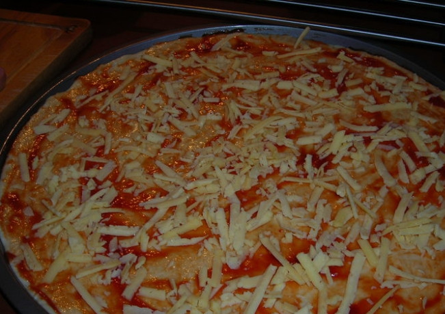 1. Этап. Пицца с сосисками и сыром: 2. Твердый сыр измельчаю на крупной терке, посыпаю им корж (использую половину).