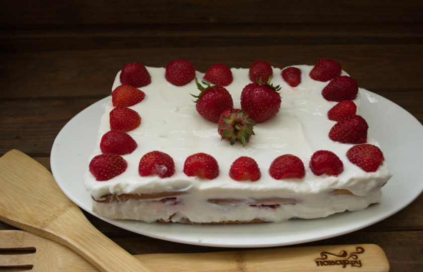 1. Этап. Клубнично-творожный торт без выпечки: Украсьте сверху ягодами клубники по вашему вкусу и подайте к столу. Торт требует пропитки в холодильнике около 2 часов перед подачей.