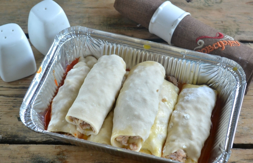 1. Этап. Каннеллони с фаршем под томатным соусом: На каждый прямоугольник теста положите начинку, заверните тесто в трубочки. Сложите трубочки в форму для запекания.