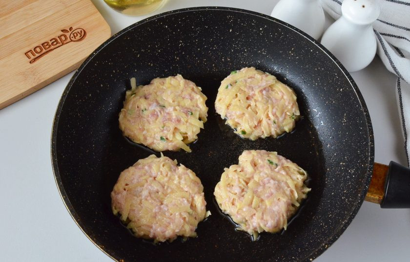1. Этап. Драники картофельные с фаршем: Разогрейте ложку масла в сковороде, выкладывайте ложкой или формируйте драники мокрыми руками, как удобно. Жарьте под крышкой до золотистой корочки.