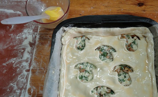 1. Этап. Пирог с грибами из слоеного бездрожжевого теста: 10. Накрыть тестом начинку, плотно закрепив края и смазав верх взбитым яйцом. Вырезанные грибочки можно выложить сверху или отдельно обжарить. Отправить противень в разогретую духовку на 30-40 минут.