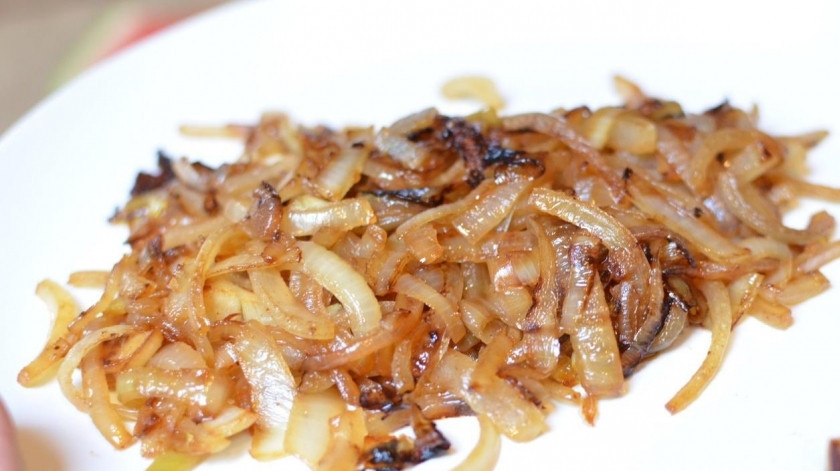 1. Этап. Салат с курицей и опятами: В той же сковородке, где обжаривали курицу, теперь обжариваем нарезанный тонкими полукольцами лук до золотистого цвета.