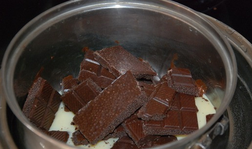 1. Этап. Печенье Орешки с шоколадом: В миску с горячей водой ставим на небольшой огонь миску меньшего диаметра. Выкладываем в нее сгущенку и ломаем шоколад. Где-то через 1-2 минуты нужно все это размешать до эластичной блестящей массы.