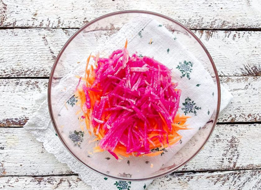 1. Этап. Редька с чесноком и морковью: Редьку очистите от кожуры, натрите на терке для корейских салатов и добавьте ее к моркови.