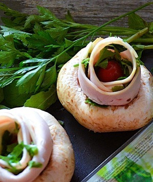 1. Этап. Шампиньоны с ветчиной и сыром: Добавить черри и рубленую зелень, свернуть рулетом, поместить в гриб. Также сделать и со вторым ломтиком ветчины.