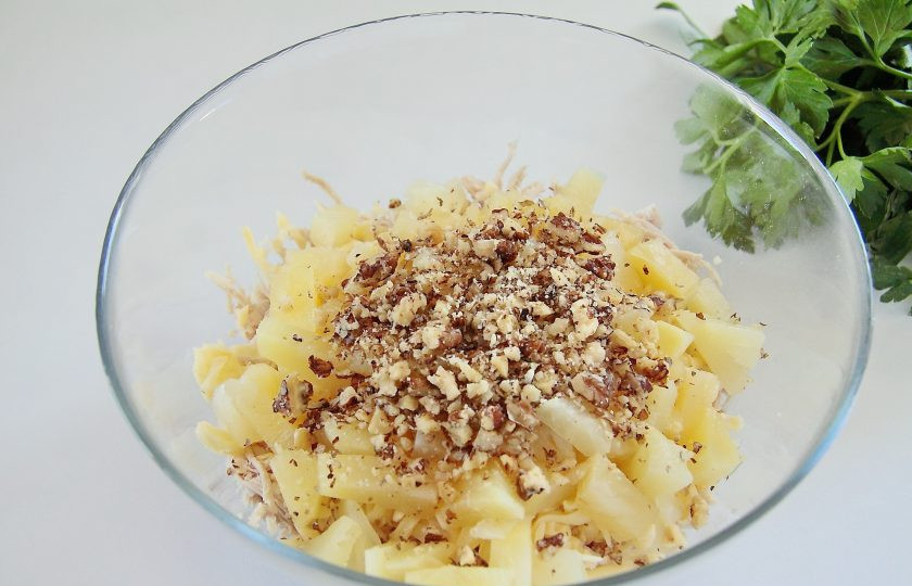 1. Этап. Салат из индейки с ананасом: Орехи измельчите. Оставьте немного для украшения, остальные отправьте в миску.