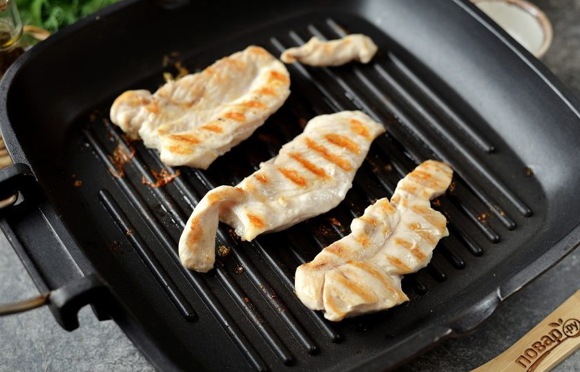 1. Этап. Овощной салат с курицей и фасолью: Филе нарежьте тонкими ломтиками, обжарьте на сухой сковороде-гриль минуты по 3-4 с каждой стороны.