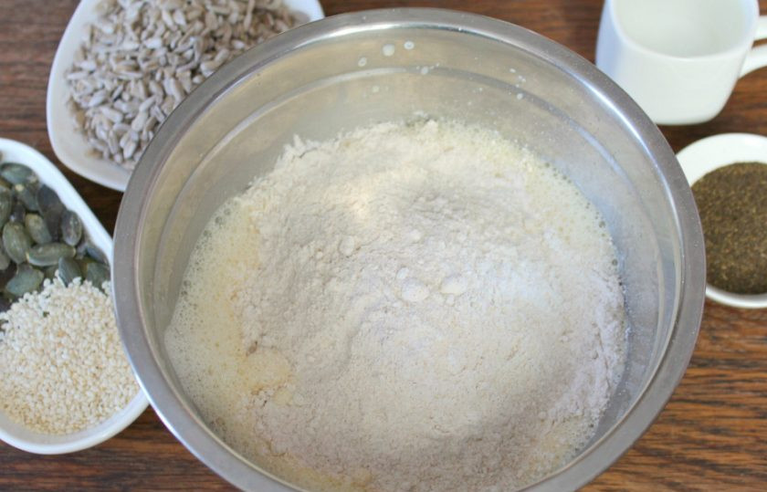 1. Этап. Галеты с семечками: Насыпаем муку, соль, сахар и соду. Добавляем немного теплой воды и все перемешиваем.