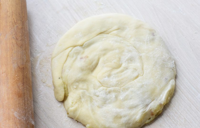 1. Этап. Слоеные лепешки с луком на сковороде: Эту улитку раскатайте скалкой в тонкую лепешку.