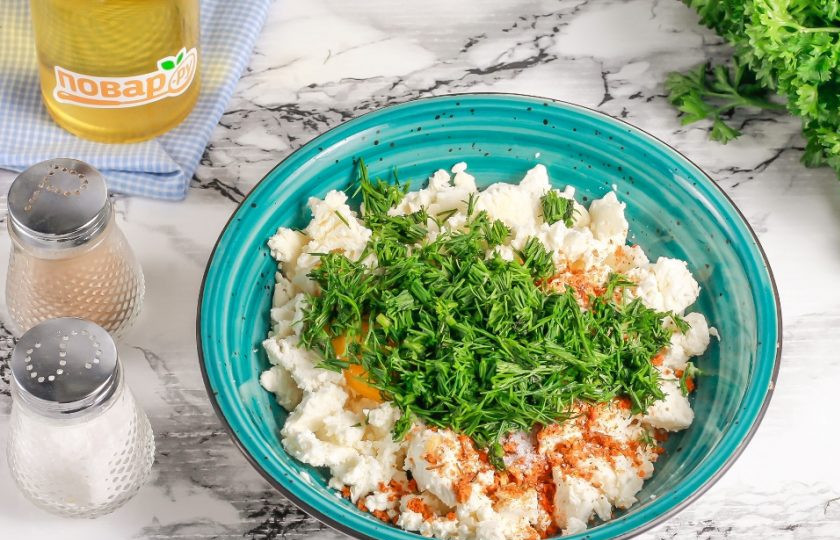 1. Этап. Несладкие сырники: Промойте и измельчите зелень укропа, добавьте в емкость. Тщательно перетрите все вилкой.