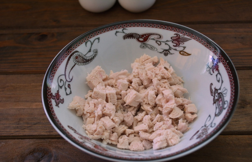 1. Этап. Салат Орхидея с курицей: Куриный окорок отварить. Снять кожу и удалить кости. Мякоть нарвать на мелкие кусочки.