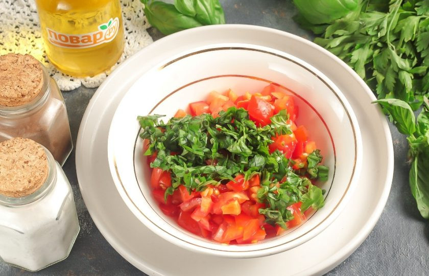 1. Этап. Брускетта с базиликом: Помидоры и базилик промойте в воде, нарежьте овощи кубиком, а зелень — мелко порубите. Выложите в салатник и полейте бальзамическим соусом, присыпьте солью. По желанию можно добавить другие соусы и специи. Перемешайте.