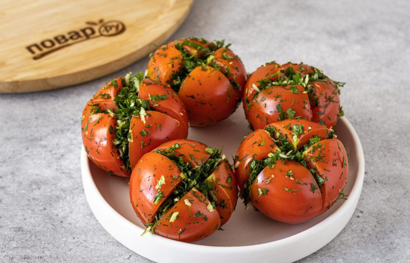 1. Этап. Малосольные помидоры с чесноком и зеленью: Заполните надрезы зеленью с чесноком.