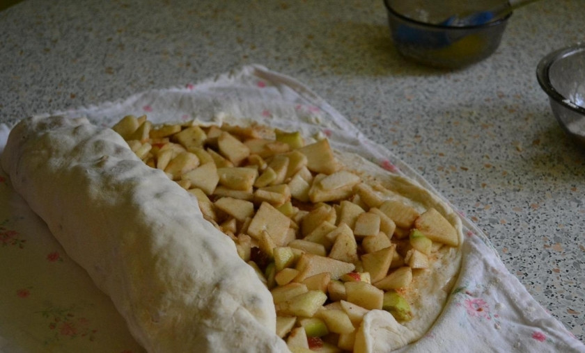 1. Этап. Яблочный штрудель из бездрожжевого теста: 9. С помощью ткани сворачиваю тесто рулетом таким образом, чтобы начинка не выпала.