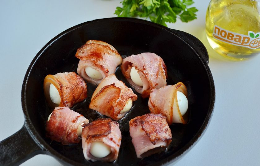 1. Этап. Закуска из яиц в беконе: 4. Разогрейте растительное масло. Положите яйца в беконе так, чтобы край бекона был снизу и первым поджарился, тогда яйцо не развернется. Потом переверните, обжарьте со всех сторон.