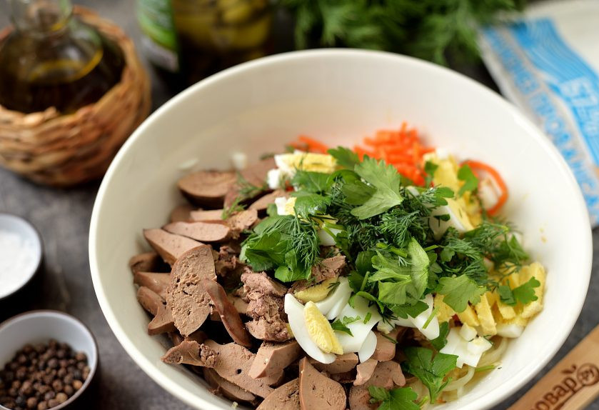 1. Этап. Салат из куриной печени с морковью по-корейски: Остывшую печень нарежьте также тонкими ломтиками, нарубите зелень, измельчите вареные яйца. Переложите все ингредиенты в миску.