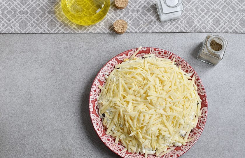 1. Этап. Простой салат с шампиньонами жареными: Сверху посыпьте салат тертым сыром. Натрите на крупной терке. Сыр лучше брать нейтрального вкуса с приятным сливочным ароматом, например, 