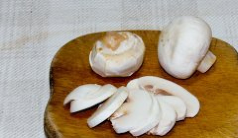 1. Этап. Вегетарианский салат с авокадо: Снимите с шампиньонов кожуру, тонко нарежьте грибы.