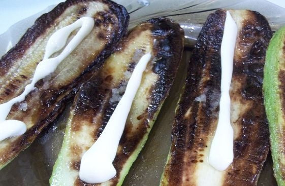 1. Этап. Закусочные рулетики из кабачков: Обжаренные кабачки немного остудите и выложите на тарелку. Затем пропустите через пресс очищенный чеснок, смажьте им кабачки. Поверх чеснока выложите на овощи немного майонеза.