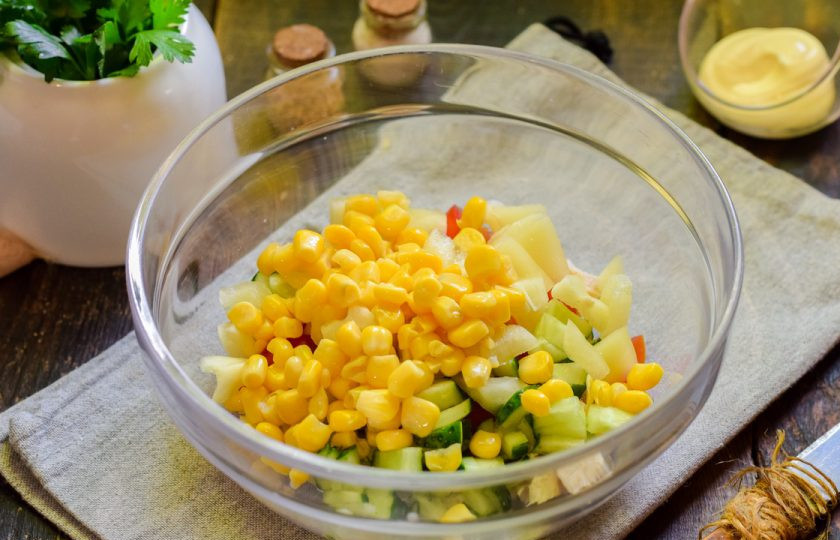 1. Этап. Салат Калейдоскоп с курицей: Добавьте в салат консервированную кукурузу, соль и перец.