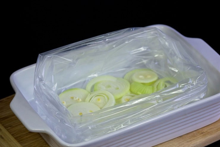 1. Этап. Ростбиф из говядины классический: В форму для выпечки уложите пакет для запекания. На его дно уложите один лук, нарезанный колечками.