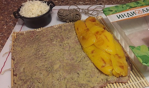 1. Этап. Рулет из индейки к Новогоднему столу: Дайте перцам остыть и уберите кожицу с подпалам. Индейку положите на циновку, смажьте горчицей. Положите очищенные от кожицы перцы