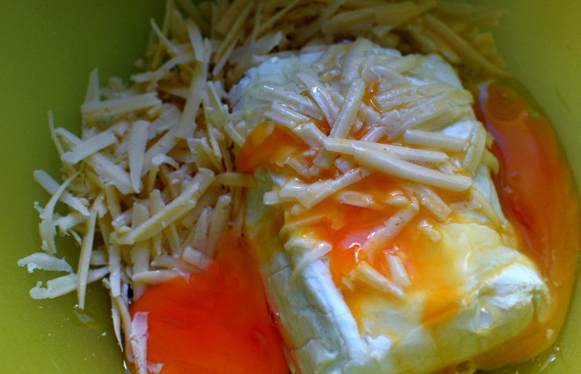 1. Этап. Творожная запеканка с зеленью и сыром: Хорошо вилкой смешайте творог с тертый сыром, яйцом и солью. Добавьте муку и крахмал, смешанные со щепоткой соды. Легко перемешайте.