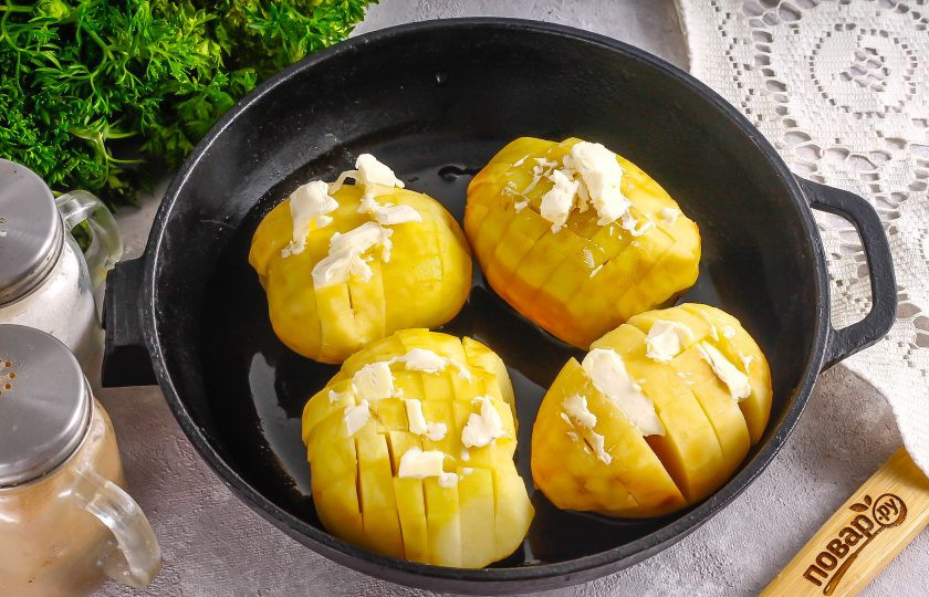 1. Этап. Картофель Гассель: Картофель очистите от кожуры и промойте в воде. С плоского бока каждой картофелины срежьте донышко, чтобы она не укатывалась. Затем нарежьте вдоль и поперек, но не до конца, чтобы получилась как будто нарезка картофеля фри. Так поступите с каждым корнеплодом. В промежутки между нарезкой вложите сливочное масло. Смажьте форму растительным маслом, разогрейте духовку до 200 градусов. Выложите картофель в форму.