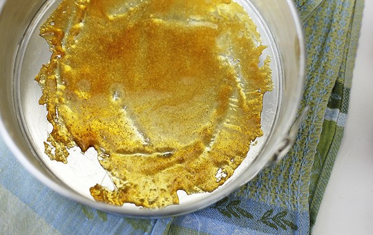 1. Этап. Шарлотка с карамелизированными яблоками: Карамель распределите по дну формы и положите кусочки масла.