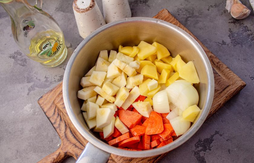 1. Этап. Суп-пюре из зеленого консервированного горошка: В кастрюлю выложите очищенные и нарезанные на небольшие кусочки лук, морковь, картофель и кабачок.