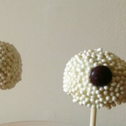 1. Этап. Десерт в виде овцы: Накалываем шарики на деревянные палочки. Присыпаем бусинками для торта. С помощью шоколадных конфеток делаем мордочку и лапки.