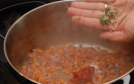 1. Этап. Турецкий суп из чечевицы: 4. Когда лук немного поджарится, добавьте морковь и обжарьте пару минут, помешивая. Выложите в кастрюлю томатную пасту, сахар и фенугрек, если есть.