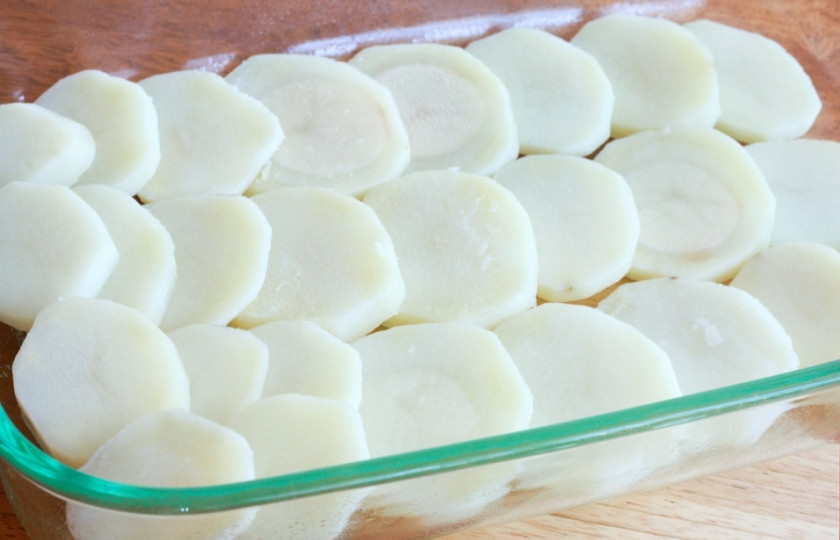 1. Этап. Запеканка картофельная с баклажанами: 1. Выкладываем первый слой картофеля. Нарезаем его тонкими дольками и в один слой выкладываем на дно. Теперь то тут, то там побросаем кусочки сливочного масла. Немного солим.