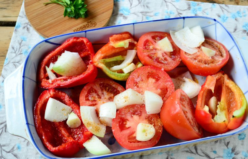 1. Этап. Томатный суп с перцем и рисом: Помидоры разрежьте пополам и выложите в форму для запекания, туда же положите разрезанные пополам перчинки, лук, разрезанный на 4 части, и несколько зубчиков чеснока.