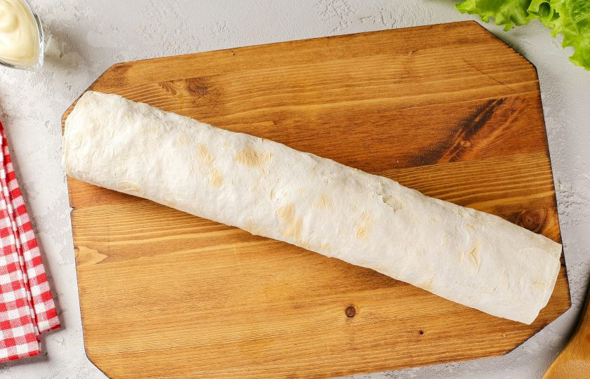 1. Этап. Лаваш с семгой: Аккуратно сверните лаваши в тугой рулет. Заверните в пищевую плёнку и отправьте в холодильник хотя бы на час.