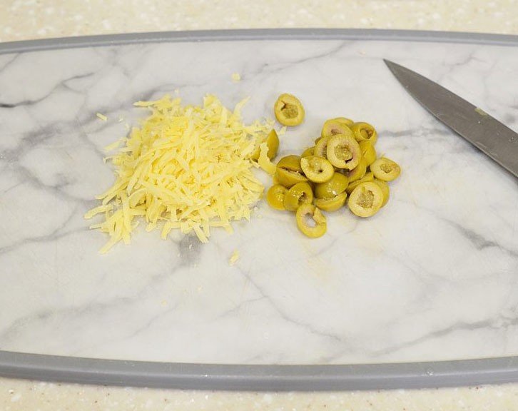 1. Stage. Squid and Mussel Salad: Grate the cheese on a fine grater, and cut the olives in circles.