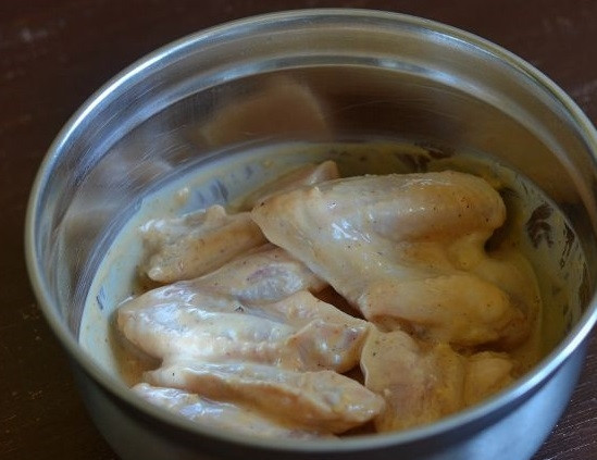 1. Этап. Крылья барбекю: Добавьте маринад к мясу, влейте масло и перемешайте. Накройте пленкой и оставьте в холодильнике на 4 часа.