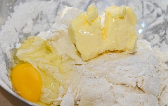 1. Этап. Сдобные пирожки с творогом: Добавляем размягченное сливочное масло и яйцо.