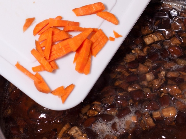 1. Этап. Суп из консервированных грибов: Положите в суп морковь и варите еще 10 минут.