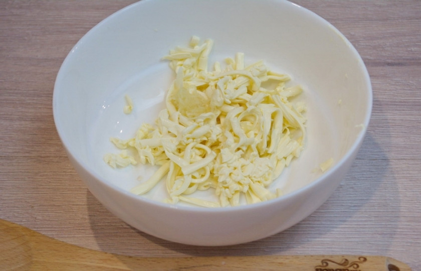 1. Этап. Лаваш в кляре: Для приготовления блюда плавленый сыр немного подержите в морозилке. Он будет плотнее. Легче будет натирать его на терке. Натрите сыр на крупной терке.