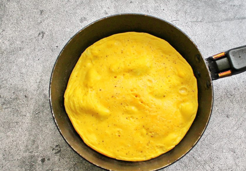 1. Этап. Омлет без масла на сковороде: Сковороду с тефлоновым покрытием нагрейте на медленном огне и вылейте в нее омлетную массу. Закройте сковороду крышкой и готовьте омлет на медленном огне в течение 10-12 минут. Яичная масса должна полностью стать плотной. Снимите сковороду с огня и переложите на тарелку. При желании можно посыпать свежей зеленью.