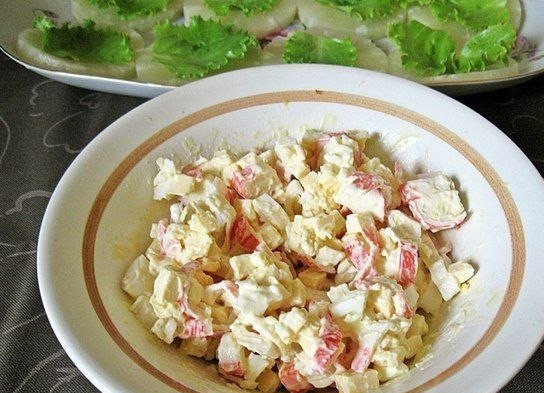 1. Этап. Ананасовая закуска: Приготовьте начинку. По сути это салат из порезанных отваренных яиц, сыра и крабовых палочек, заправленный майонезом.