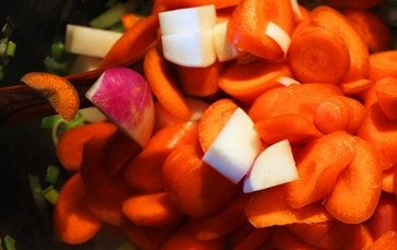 1. Этап. Уха из пикши: Потом добавьте репу с морковью и перемешайте. Влейте воду, немного посолите и ещё раз перемешайте.