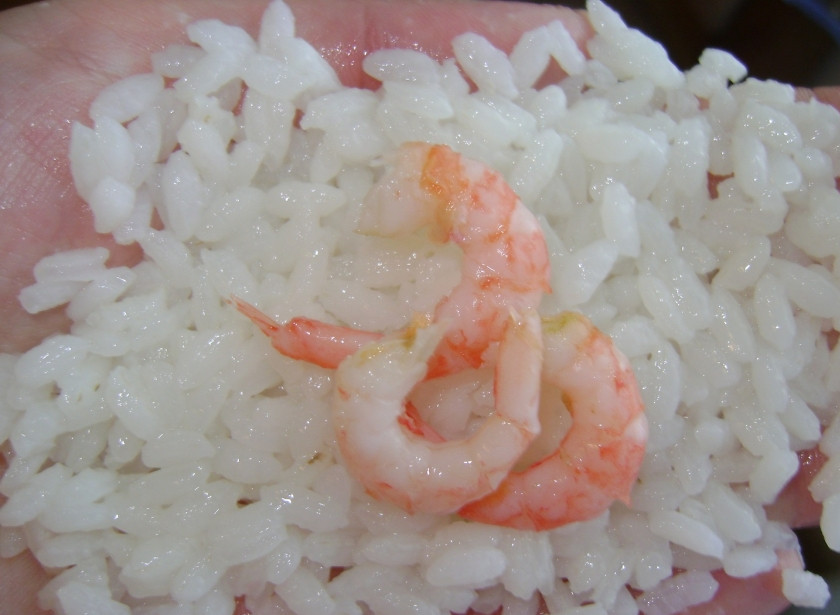 1. Этап. Рисовые шарики с начинкой: Для начала сварим рис в течении 20-25мин на медленном огне. Даем остыть. Для начанки шариков я использовала креветки. огурец и горбушу. Креветки очищаем. Огурецрежим тонкими кружками, которые потом сворачиваем. Горбушу режим небольшими кусками. Берем немного риса в руки, формируем небольшую лепешку, на которую выкладываем начинку, например креветки.