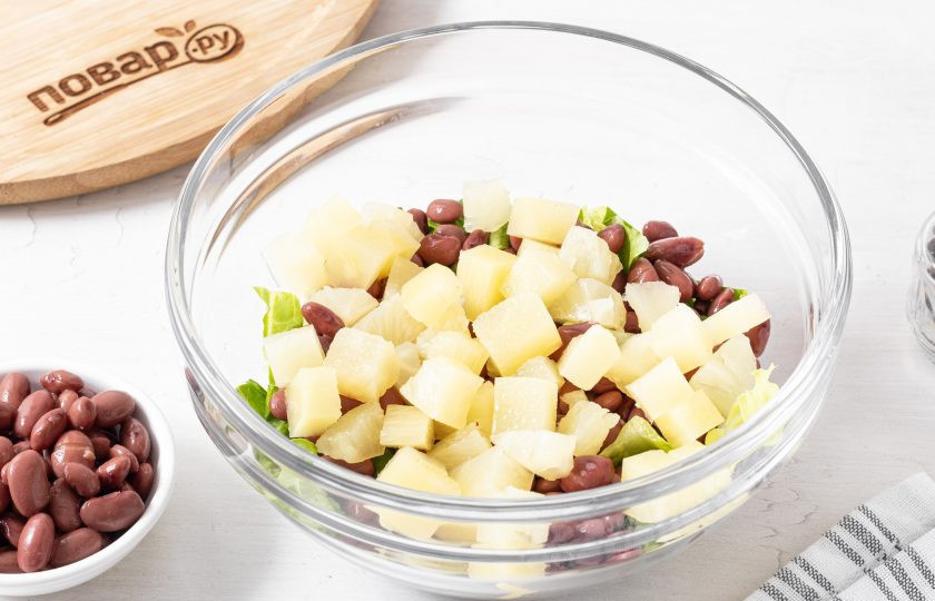 1. Этап. Салат с фасолью и ананасом: Кольца или ломтики консервированного ананаса нарежьте на небольшие кубики. Добавьте к остальным ингредиентам.