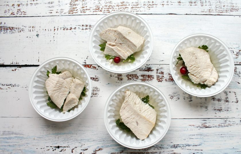 1. Этап. Заливное из грудки индейки: Отварную грудку индейки разрежьте на порционные куски и выложите поверх зелени.