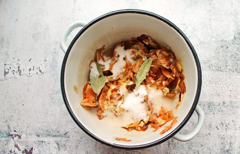 1. Этап. Сало в луковом рассоле: Луковую шелуху сполосните и выложите в кастрюлю. Добавьте соль, сахар, лавровый лист и душистый перец.