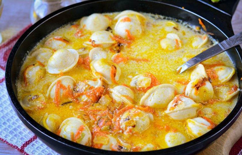 1. Этап. Пельмени тушеные с морковью и луком: Добавьте сметану смешанную с водой, посолите и поперчите по вкусу.